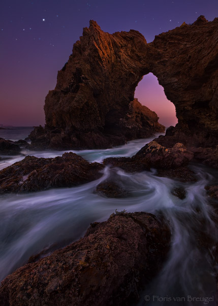 The tide comes in on one of California's rocky shores near Laguna Beach under the twilight skies. The bright 'star' is Jupiter...
