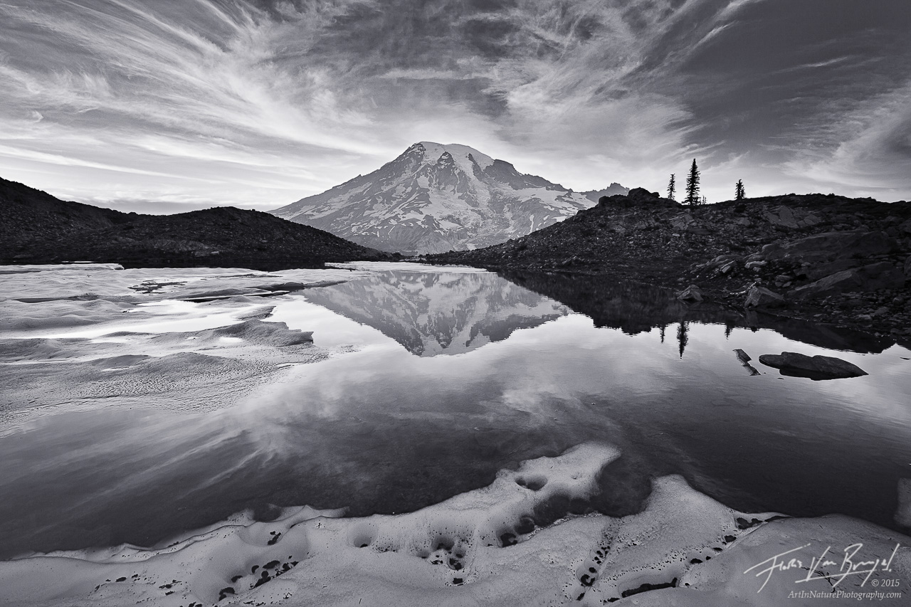 Delicate clouds form over Mt Rainier, seen reflected in a remote glacial pool.&nbsp;