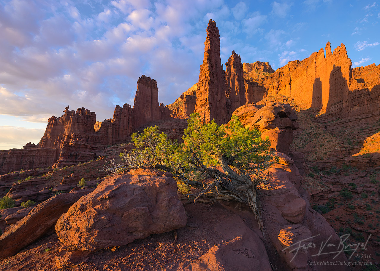 The last rays of sunshine illuminate the tall mudstone fortress of the Fisher Towers, near Moab, UT.